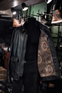 Black leather jacket held open on a mannequin to reveal patterned lining